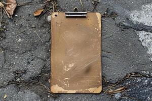 Old empty clipboard lying on the ground with copy space photo