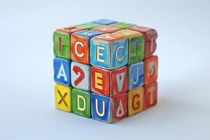 Colorful alphabet toy blocks forming a cube on white background photo