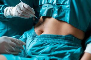 Surgeon injecting anesthesia before liposuction surgery on patient photo