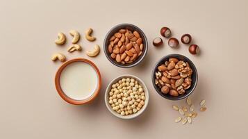 Variety of nuts and seeds in bowls with a glass of milk on a light beige background, highlighting the diversity of plant-based protein sources for a healthy diet photo