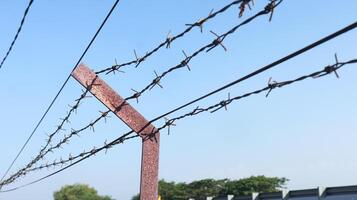 Still Life Photography of Barb wire fence against the bright cloudy sky as the background. photo