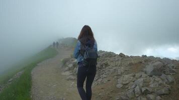 Girl walking to Kasprowy Wierch. Zakopane. Panoramic view in the fog of clouds video
