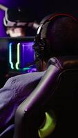 Vertical Gamer losing intense singleplayer spaceship arcade racing videogame, seeing game over screen on capable gaming computer system at home. Man upset after being defeated on difficult game level, camera A video