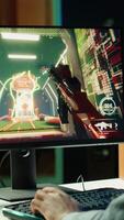 Vertical Professional gamer competing in intense online multiplayer videogame, streaming live from vibrant living room with neon lights. Man using PC, having immersive experience while gaming, camera A video