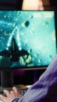 Vertical Player at home shooting asteroids in spaceship flying singleplayer game with overlay HUD showing health levels on monitor. Close up of person navigating universe in simulation game on PC video