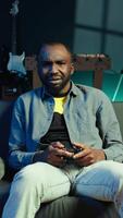 vertical irritado jogador irritado depois de perdendo dentro conectados singleplayer videogame reproduziu usando controlador. homem frustrado depois de falhando para ganhar jogos enquanto jogando em console com controle, Câmera b video