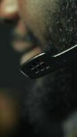 Vertical Man wearing headphones on while playing videogames at home to better immerse himself. Close up of player participating in online multiplayer esports tournament, fighting to defeat enemies, camera B video