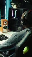 Vertical Gamer using headphones to discuss with mates while playing online SF videogame, close up. Close up enjoying futuristic coop spaceship flying arcade game with friends, chatting on internet, camera B video