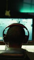 Vertical Man playing SF videogame on PC screen, shooting asteroids, putting headphones on. Close up of gamer enjoying spaceship flying game on computer desktop display, navigating through meteorites, camera B video