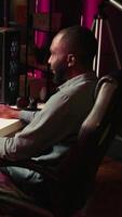 Vertical Man having fun by playing videogames on gaming PC at computer desk, enjoying day off from work. Gamer battling enemies in online multiplayer shooter from the comfort of his home, camera B video