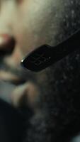 Vertical Close up of headset mic used by professional streamer competing in intense online multiplayer videogame live from home. Focus on headphones microphone used by man playing on gaming PC, camera B video