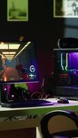 Vertical Stylish empty apartment with artwork on walls and computer screen left open at night showing videogame interface. Home living room with no people in and monitor left open video