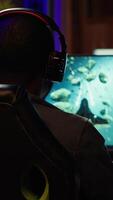 Vertical Man using headphones to enjoy online spaceship videogame with friends, shooting asteroids. Player discussing with teammates through headset microphone, flying in galaxy, camera A video