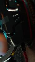 Vertical Streamer competing in intense online multiplayer videogame, streaming live at home, close up shot. Man playing on gaming PC, using headphones to discuss with viewers, camera A video
