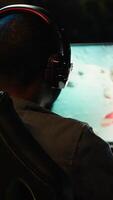 Vertical Man playing SF space videogame on PC screen in dark room wearing headphones, shooting asteroids. Gamer enjoying spaceship flying game on computer monitor, destroying meteorites, camera A video
