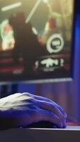Vertical Gamer playing FPS cyberspace videogames on PC monitor using computer peripherals. Close up shot of man using keyboard and mouse, playing online games on computer at desk, having fun, camera B video