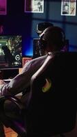 Vertical Gamer feeling annoyed after losing online multiplayer action videogame match, being outsmarted by rival players. Dejected man hitting desk after seeing game over message on computer screen, camera B video