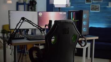 Streaming professsional microphone in empty gaming home studio with neon lights. Game is over on display of RGB professional powerful computer and stream chat is prepared for virtual tournament video