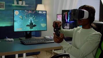 African player woman wining space shooter game using virtual reality goggles playing games with joystick. Pro cyber gamer streaming online videogames with new graphics on RGB powerful computer video