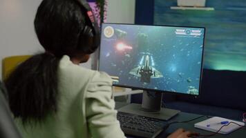 Nevous pro african cyber losing videogame, game over for woman playing online space shooter games with headset. Player performing on RGB computer talking with players on chat in gaming competition video