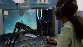 Pro cyber black woman streaming videogame, reading on stream chat and playing space shooter on RGB powerful computer. Streamer sitting on gaming chair playing game during online esports tournament. video
