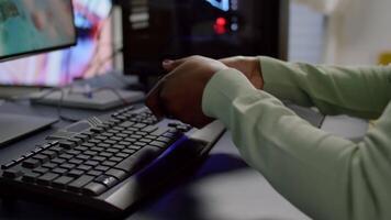 Close-up of professional cyber gamer holding joystick playing space shooter game. Pro player use RGB equipment during gaming tournament late at night in home studio using wireless controller video