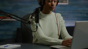 Portrait of african smiling blogger looking at camera before starting live from home studio podcast. Content creator vlogger woman recording brodcast streaming online content for social media video