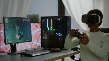 Black videogamer woman winning space shooter game using virtual reality goggles playing games with modern joypad. Professional gamer streaming online videogames with new graphics on powerful computer video