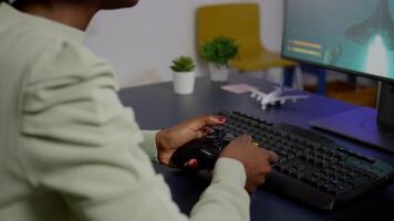 Closeup of wireless joystick and RGB keyboard, pro gamer playing online games on powerful computer. Player using professional equipment during gaming online competition video