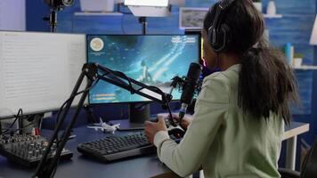 Streamer cyber performing space shooter game holding controller on RGB powerful computer talking with players on stream chat and microphone during professional competition. Player man streaming video