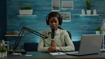 Famous young african woman recording a vlog for subscribers using podcast microphone for vlogging. On-air online production internet broadcast show host streaming live content for social media video