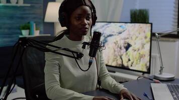 Black vlogger speaking with followers on live podcast using microphone wearing headphones. Creative online show On-air production internet broadcast host streaming live content video