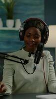 Vertical . Influencer making online internet content for web subscribers using camera in home podcast studio during livestreaming. On-air online production broadcast show host streaming live content video