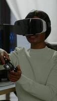 Vertical . Winner player holding joystick playing videogame in gaming room using virtual reality. Professional pro gamer streaming online videogames with new graphics on powerful computer using modern equipment. video