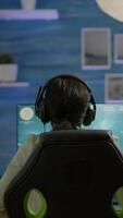 Vertical . Cyber gamer playing game with new graphics winning championship, sitting in gaming room. Virtual game in cyberspace, esports player performing tournament on RGB profesional computer video
