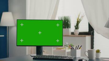 Empty bright living room with isolated mock-up green screen chroma key monitor standing on desk. Home office with nobody lying on is ready for business network video