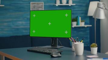 Close up of professional powerful computer with mock up green screen chroma key standing on table in bright living room with nobody in it. Pc with isolated display is ready for online business video