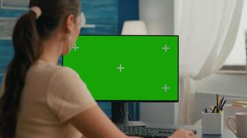 Woman sitting at office desk and searching on internet for commerce business using computer with mock up green screen chroma key. Caucasian female working with isolated pc video