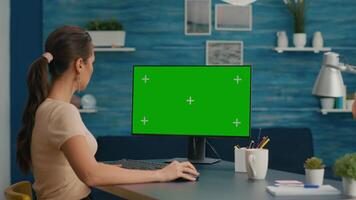 Caucasian woman working on mock up computer green screen chroma key for business communication project. Freelancer sitting at desk in office home using isolated pc video