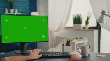 Pov of man hands sitting on office desk using computer with mock up green screen chroma key working video