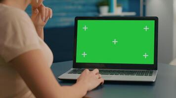 Close up of freelencer typing on isolated laptop for business commerce. Caucasian woman working on computer with mock up green screen chroma key display in home office studio. video