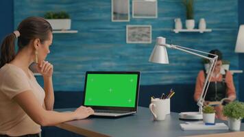 Woman working at businees project for company using laptop computer with mock up green screen chroma key. Caucasian freelencer using isolated pc while standing in home office studio video