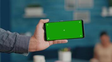 Front view of horizontal isolated mock up green screen chroma key display of modern smartphone. Business woman using isolated phone for browsing social networks sitting on office desk video