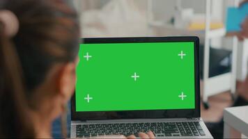 Close up of laptop computer with mock up green screen chroma key display. Business woman lying on sofa and typing on isolated pc for commerce project in home office video