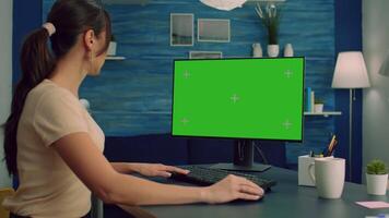 Freelancer looking for marketing information on internet using personal computer with mock up green screen chroma key. Business woman working with isolated pc at office desk in living room video