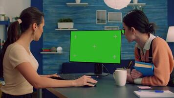 Teammates browsing on internet for commerce advertising using powerful computer with mock up green screen chroma key display. Collegues working on isolated pc sittings at desk table in office studio video