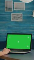 Vertical . Freelancer using computer with mock up green screen chroma key for business company standing on desk table. Woman using isolated home office pc working at commerce project in home office video