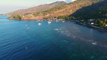 Coastline with quiet ocean, mountains and evening sunlight at North Bali, drone view video