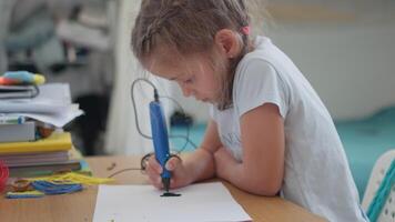 Smart girl drawing with 3D pen on paper at table video