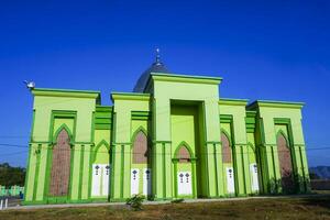 Photo of a magnificent green mosque under a blue sky